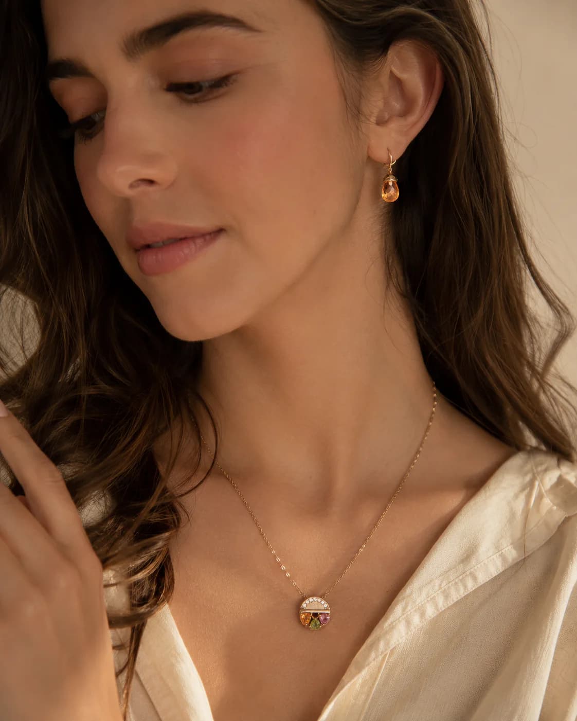 A model wearing jewelry in warm natural light